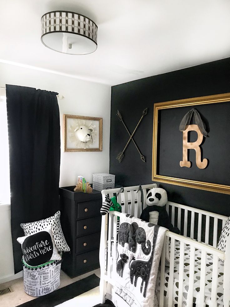 a baby's room with black walls and white bedding, including a crib