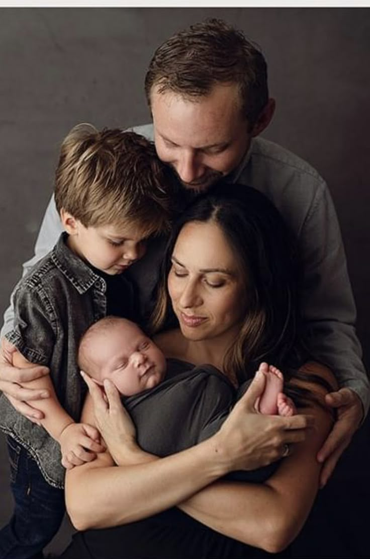 a man and woman holding a baby in their arms