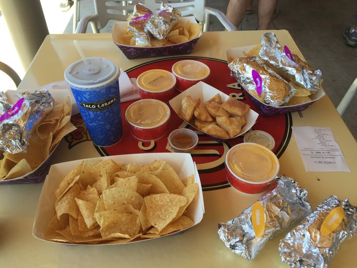 a table topped with plates of food and cups of drinks next to each other on top of a red tray