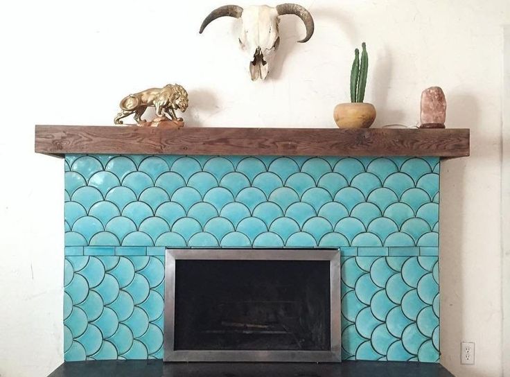 a fireplace is decorated with blue tiles and deer heads