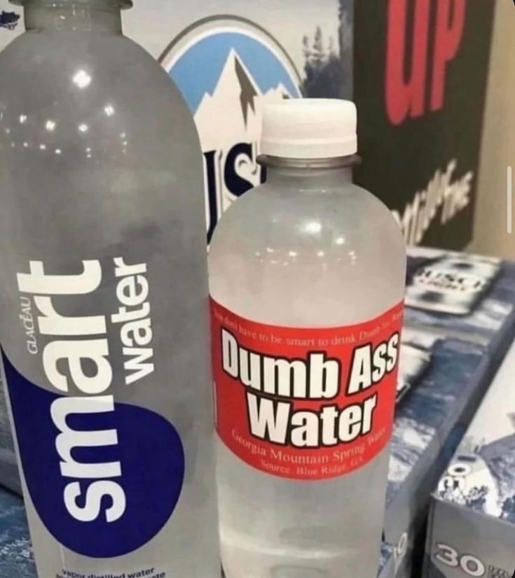 two water bottles sitting on top of a table next to boxes and other items in the background