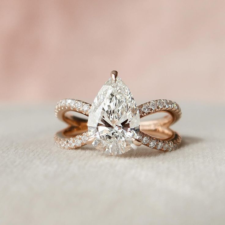 an engagement ring with a pear shaped diamond in the center and side stones on each band