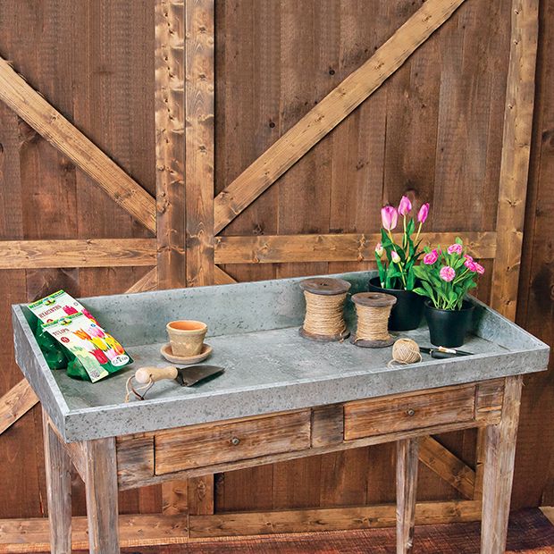 a cement table with flowers on it and two potted plants sitting on the top