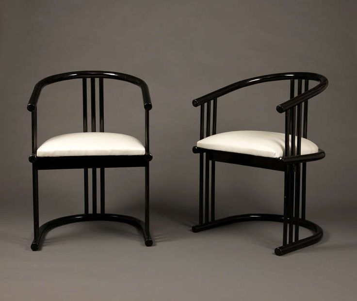 a pair of black and white chairs against a gray background