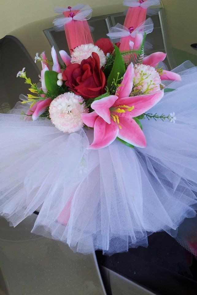 a white tutu with pink and red flowers on it sitting on a chair in front of a wall