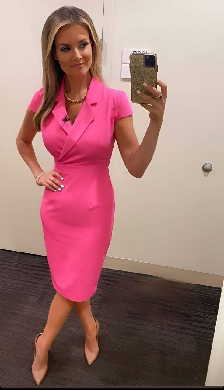 a woman taking a selfie in a mirror wearing a pink dress and matching heels