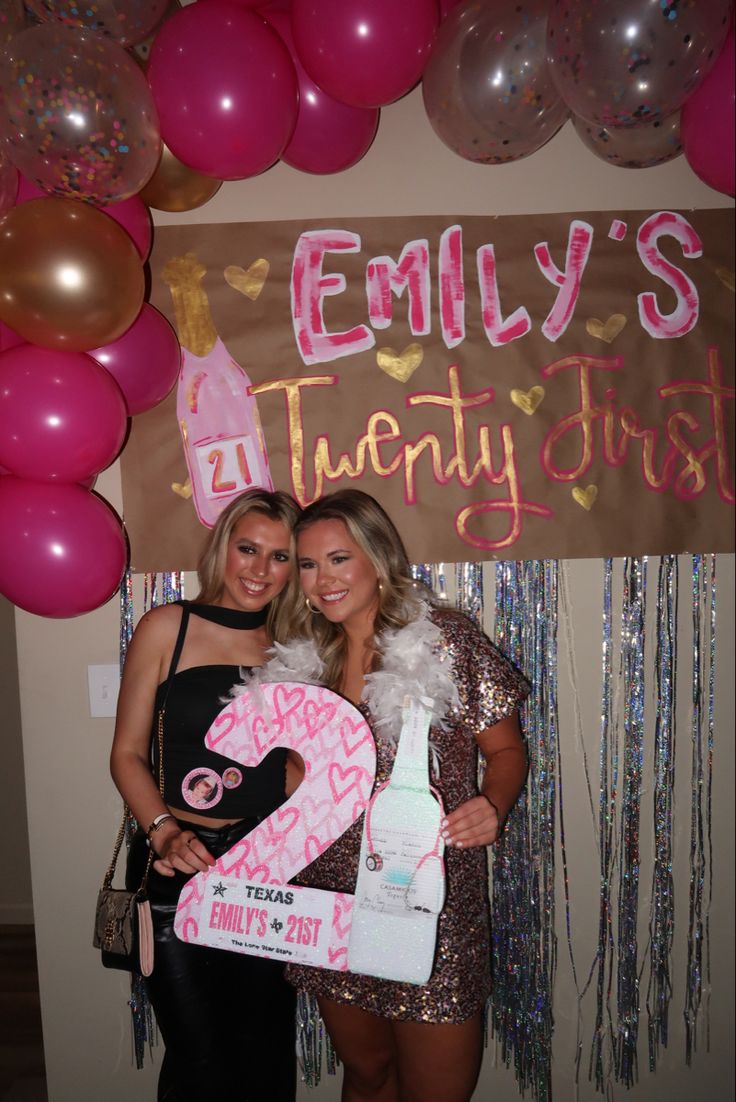 two women standing next to each other in front of balloons and a sign that says, enly's twenty first