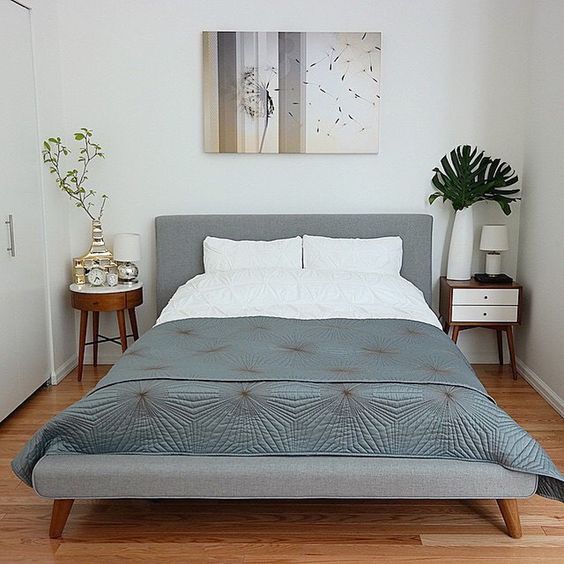 a bed with white sheets and pillows in a room