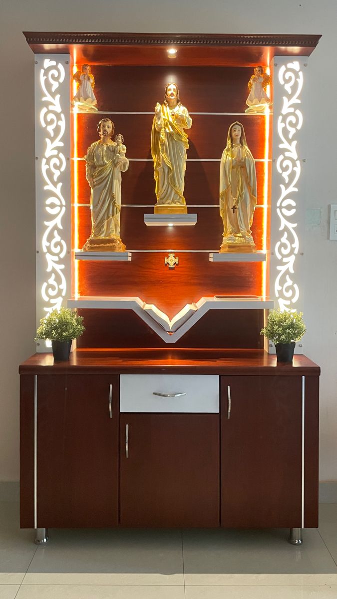 the statue is on display in front of an illuminated cabinet with three statues and two potted plants