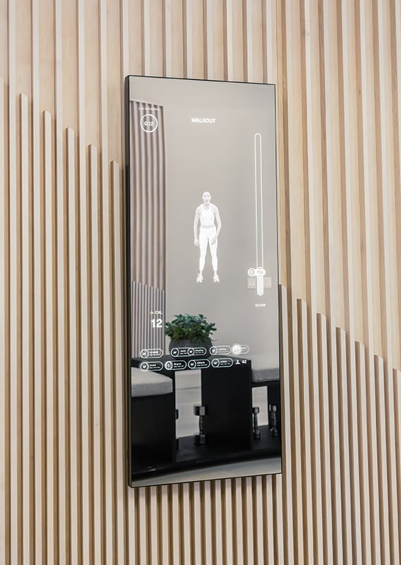 a mirror reflecting a man's reflection in front of a wall with wooden slats