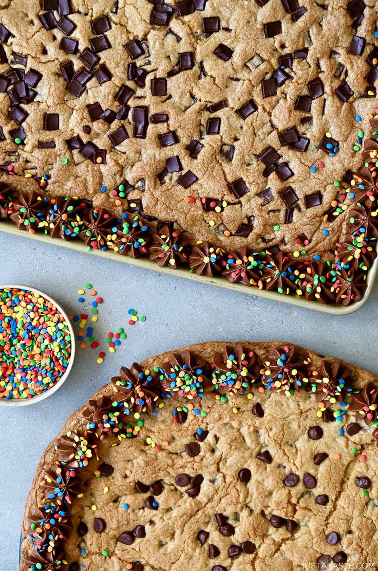 chocolate chip cookies and sprinkles are arranged in pans on a table