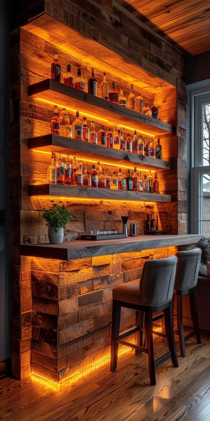 a wooden bar with lighted shelves and stools in front of the bar is lit up by orange lights