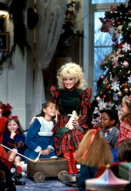 dolly on stage with children in front of christmas tree and presents around the room, all dressed up