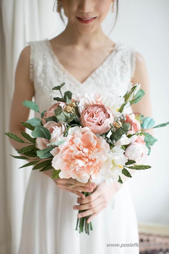 a woman holding a bouquet of flowers in her hands