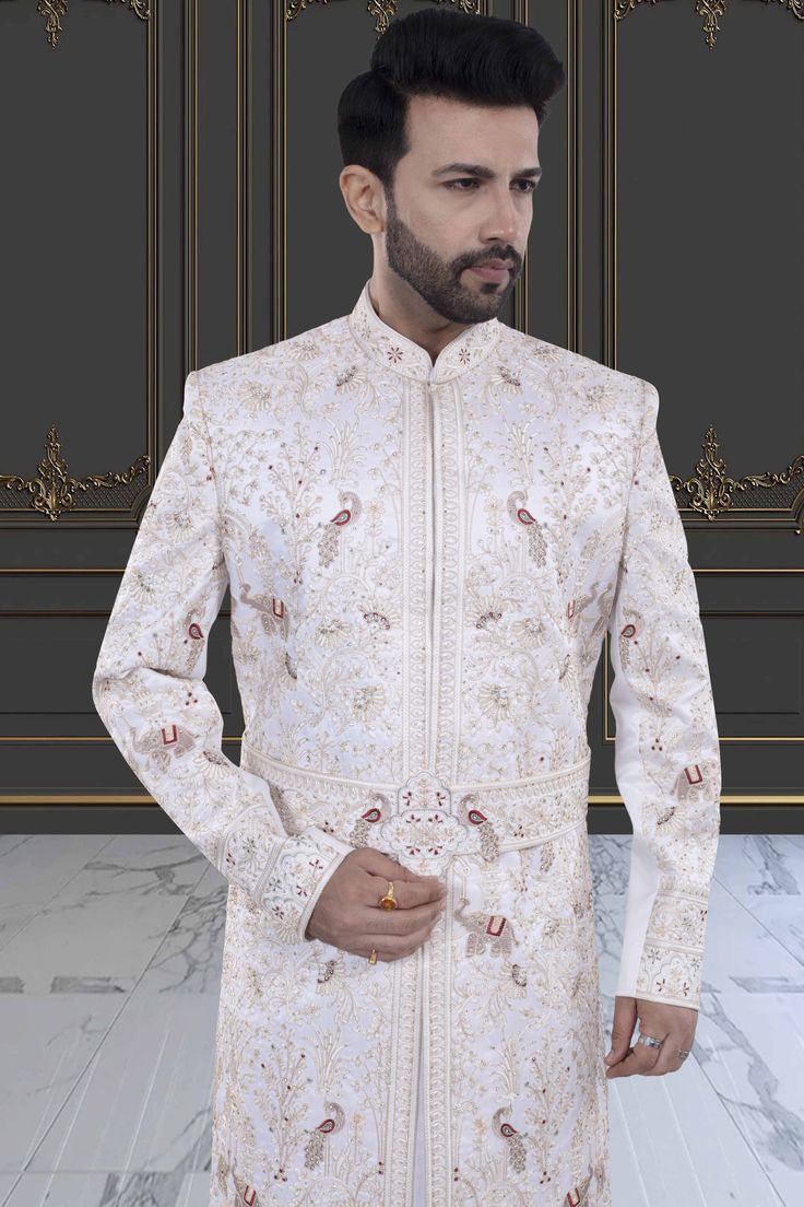 Introducing the V20-S45 Mens Sherwani, adorned with intricate peacock and elephant embroidery. This stunning white sherwani is accented with rich red details. Perfect for grooms seeking luxurious elegance on their special day. Elevate your style with this exclusive piece. Elegant Nehru Jacket For Traditional Ceremonies, Fitted Sherwani With Intricate Embroidery For Traditional Ceremonies, Fitted Sherwani With Resham Embroidery For Traditional Ceremonies, Elegant Sherwani For Traditional Ceremonies, Formal Fitted White Traditional Wear, White Nehru Jacket With Naqshi For Transitional Season, Elegant Nehru Jacket For Diwali Ceremonies, Elegant Sherwani With Dabka For Traditional Ceremonies, Elegant Sherwani With Intricate Embroidery For Traditional Ceremonies