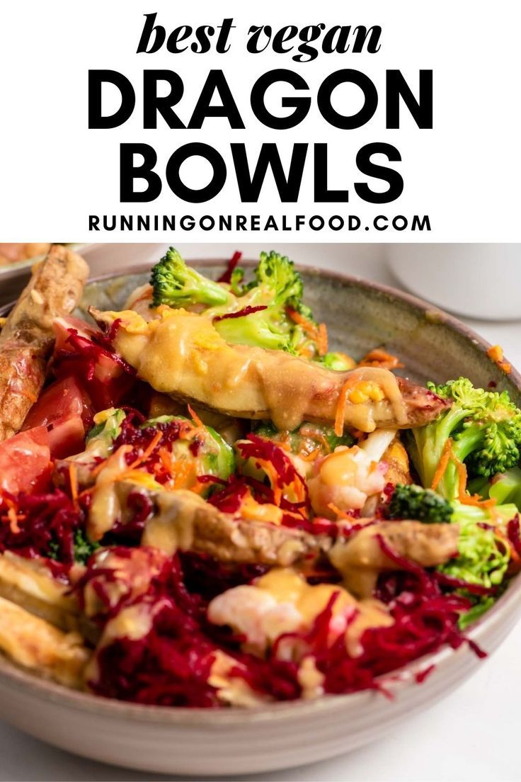 a bowl filled with broccoli, chicken and other vegetables on top of a white table