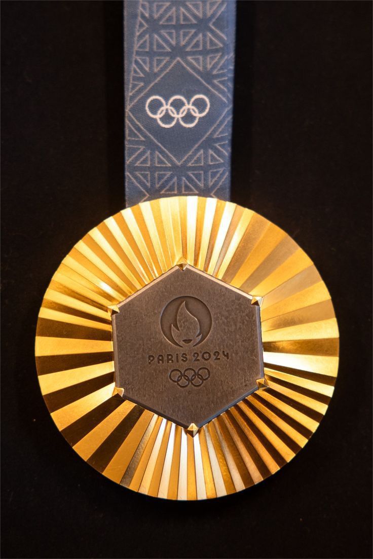 a gold medal with the olympic logo on it