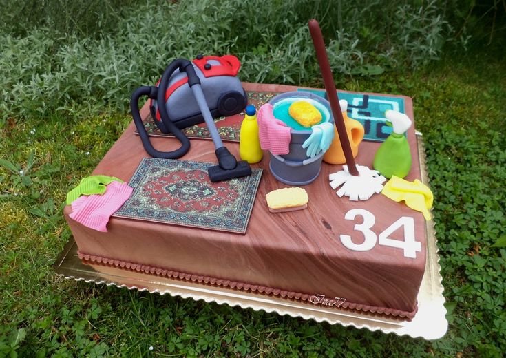 a cake that is sitting in the grass on top of a table with items around it