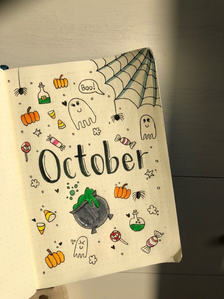 an open notebook with the words october written on it and halloween doodles in front