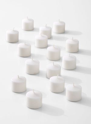 many white candles are arranged in the shape of a triangle on a white surface with shadows