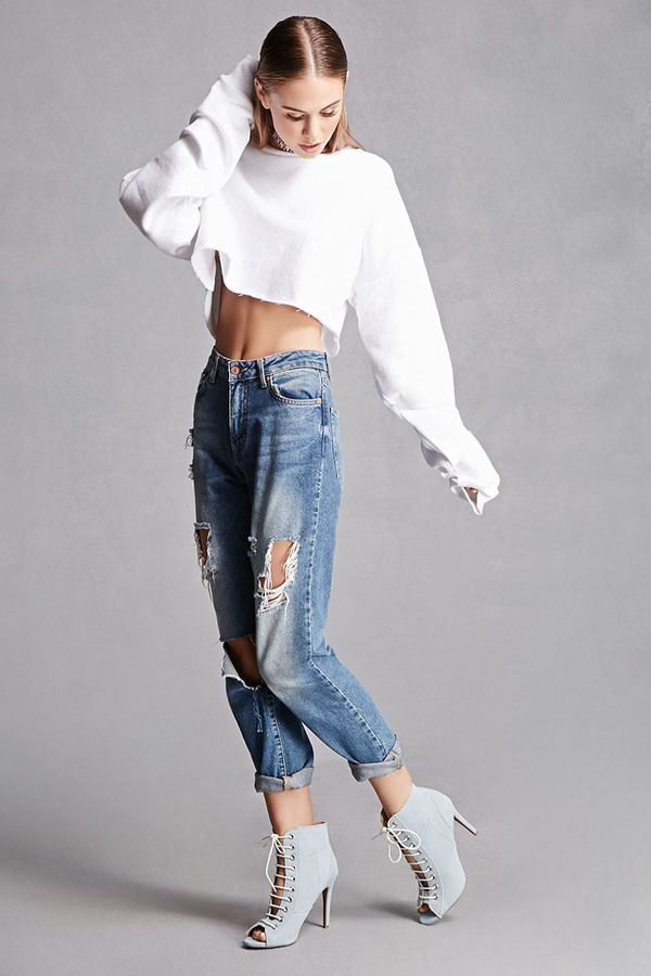 a woman in ripped jeans and white crop top