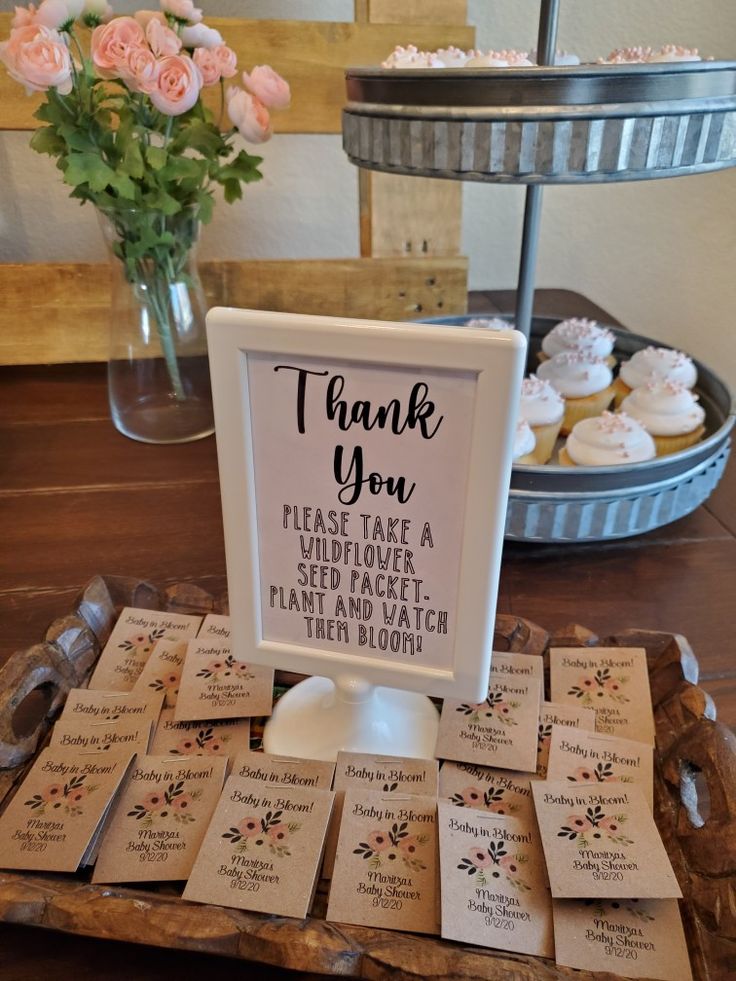 a table topped with lots of cupcakes next to a sign that says thank you