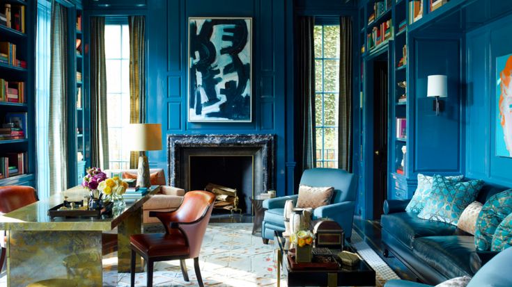 a living room filled with lots of furniture and bookshelves covered in blue paint