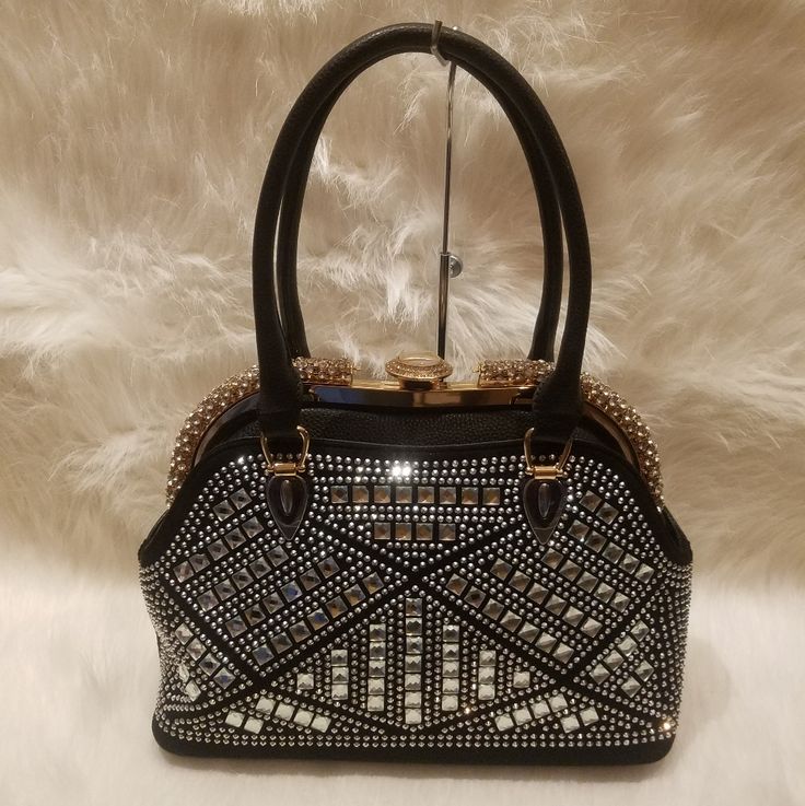 An Patterned Rhinestone Design Gives This Hand Bag A Truly Unique Edge. The Show Stopping Silhouette Also Features A Classic Frame Opening With A Rhinestone Finish. Has Back Zipper Pocket Double Handles With A 7 Inch Drop Length Detachable Strap With A 22 Inch Drop Length Made Of Faux Leather Construction Fully Lined Interior Two Interior Slip Pockets And One Zippered Pocket And A Center Zipper Divider Pocket Aframe Clasp Closure Gold Tone Hardware. Embellished Clutch Bag For Night Out, Luxury Bedazzled Bags For Events, Handheld Evening Bags With Rhinestones, Embellished Rectangular Bag For Night Out, Embellished Rectangular Bags For Night Out, Embellished Handheld Bag For Night Out, Rectangular Embellished Bags For Night Out, Embellished Handheld Bags For Night Out, Luxury Embellished Bags For Night Out