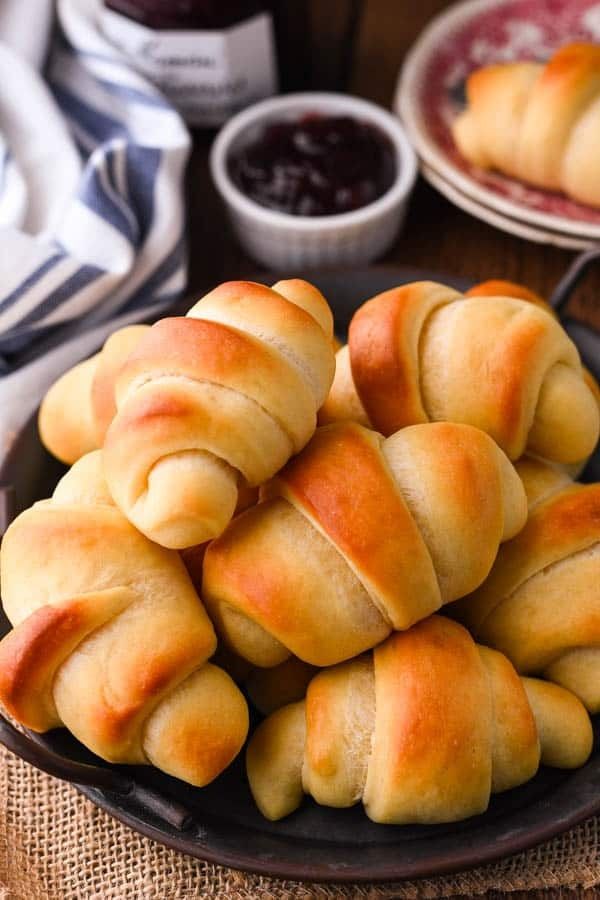 a plate full of bread rolls with jam in the background