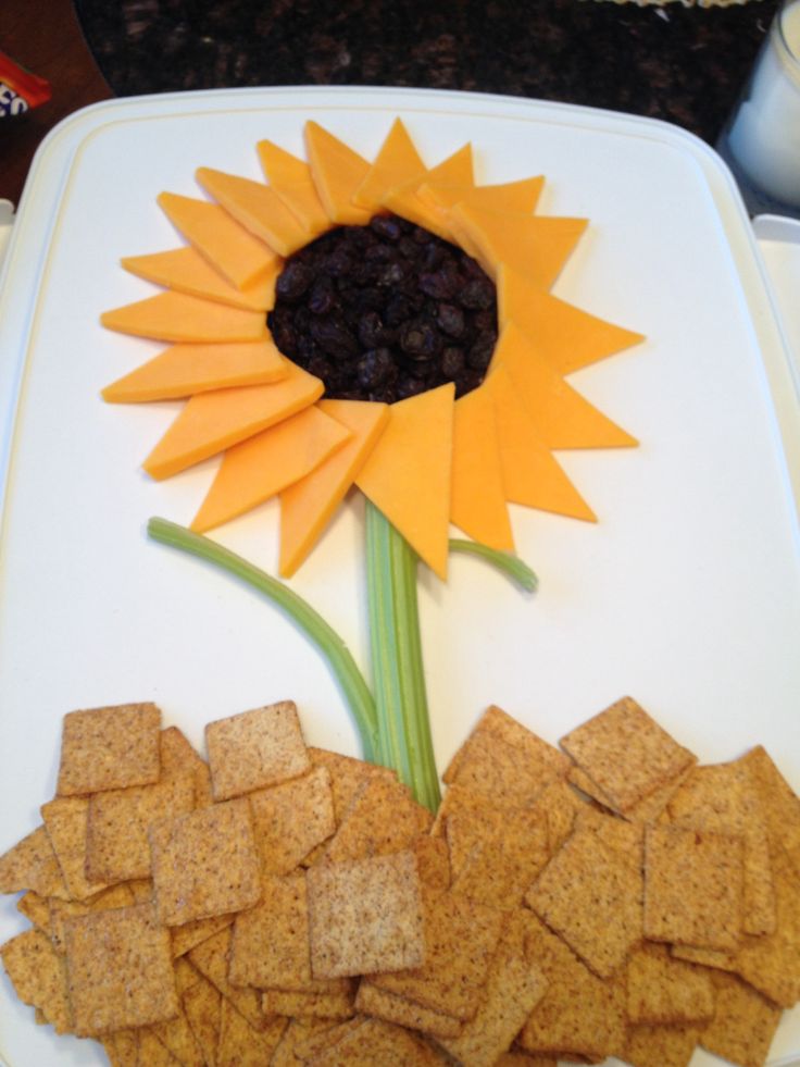 a sunflower made out of crackers sitting on top of a white platter