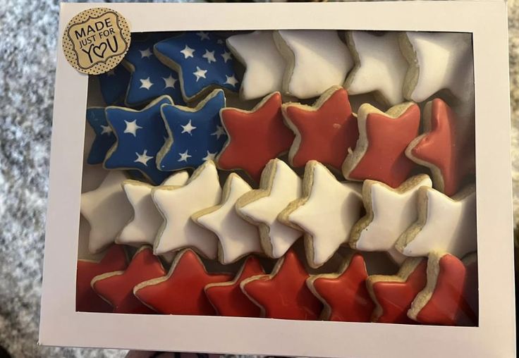 a box filled with red, white and blue cookies in the shape of stars on top of each other