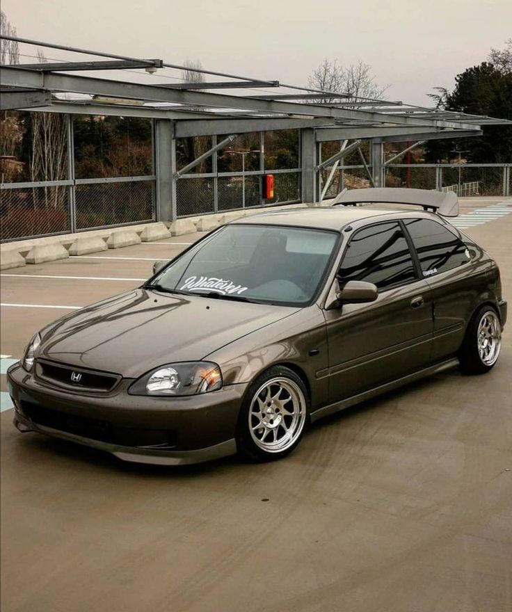 a brown car parked in front of a parking lot with no cars on it's sides