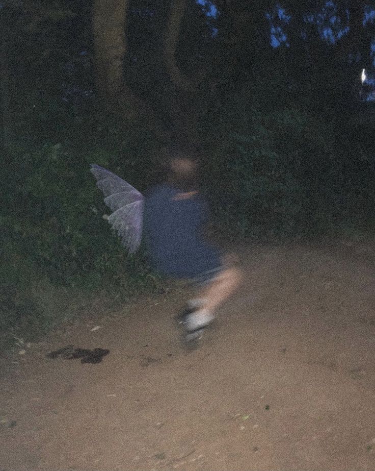 a blurry image of a person running on a dirt road at night with an umbrella