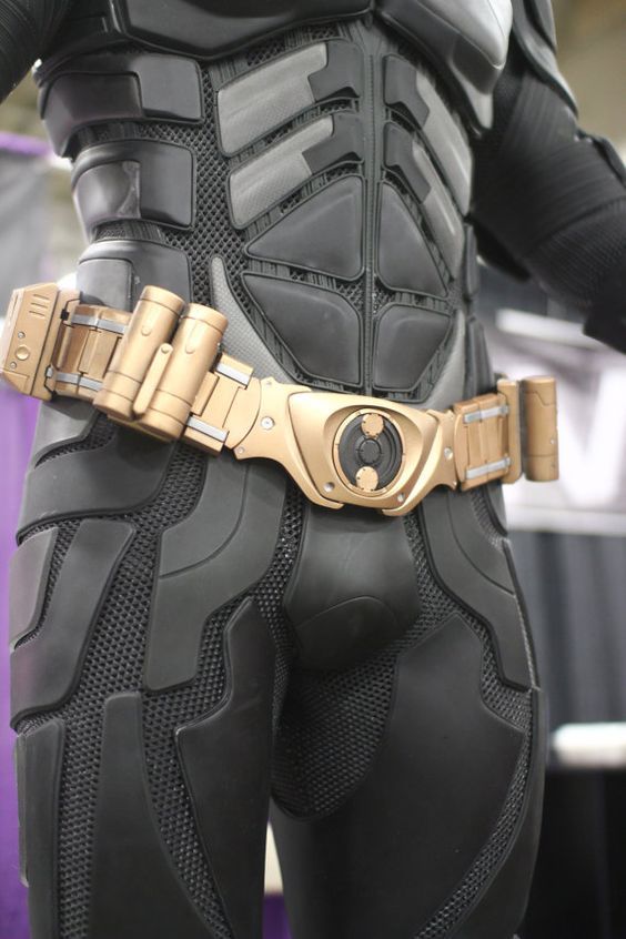 a close up of a person wearing a batman cosplay costume with gold accents