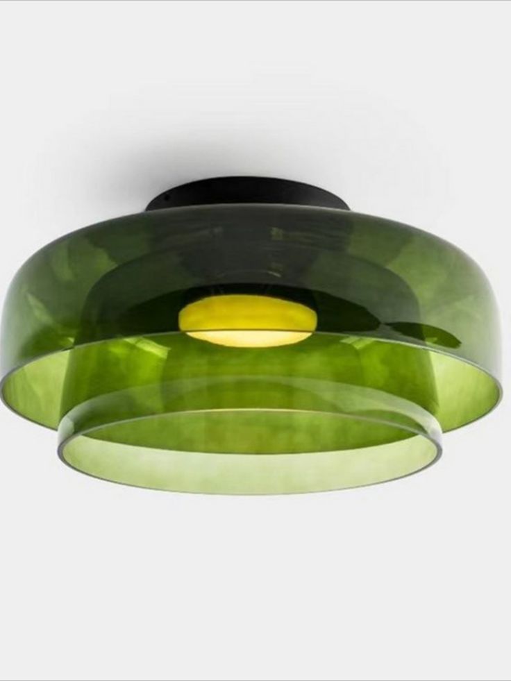 a green and yellow light hanging from a ceiling fixture with circular glass shades on it