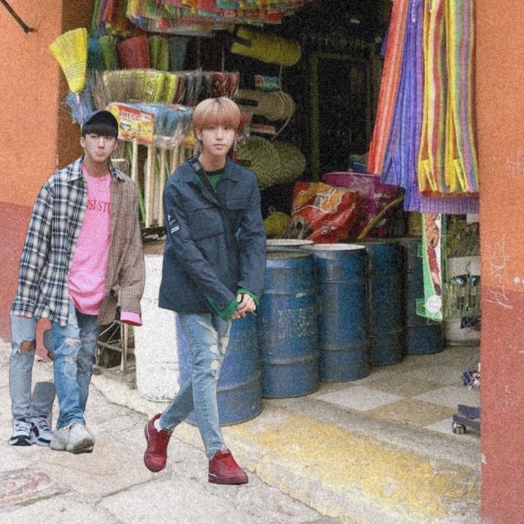 two boys are standing in front of a store