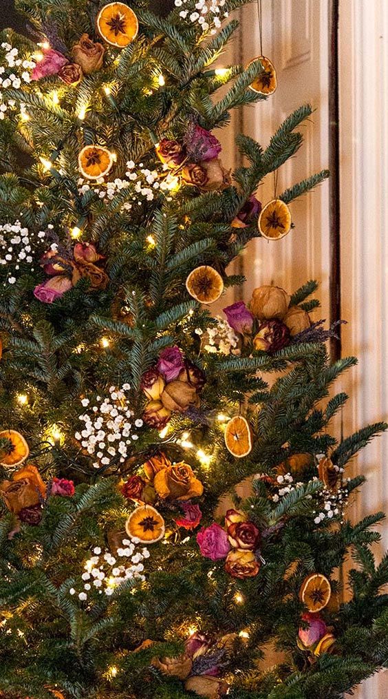 a decorated christmas tree in front of a door with lights and ornaments on the branches