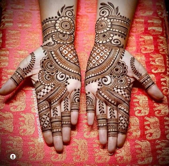 two hands with henna tattoos on them, one is showing the intricate pattern and the other