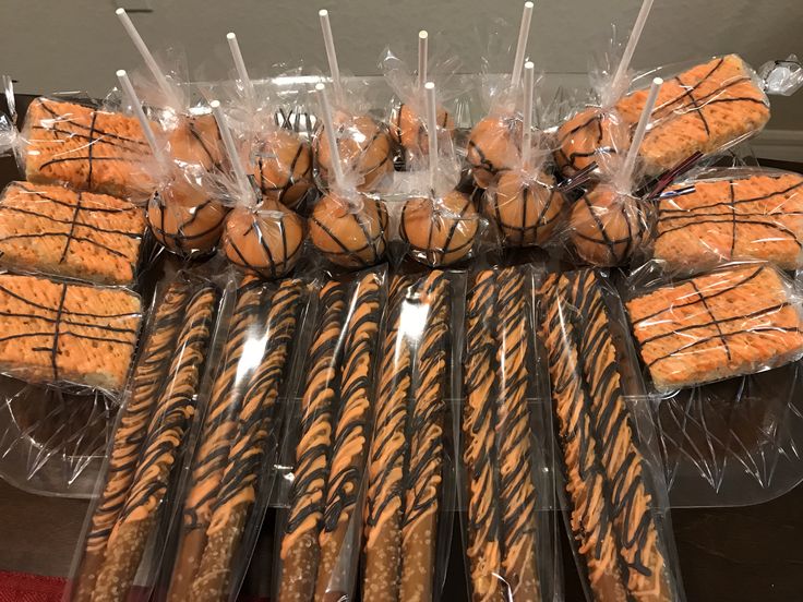 there are many cookies wrapped in plastic and sitting on top of each other with sticks sticking out of them