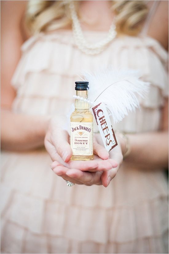 a woman holding a bottle of sauce in her hands with a feather on it's tip