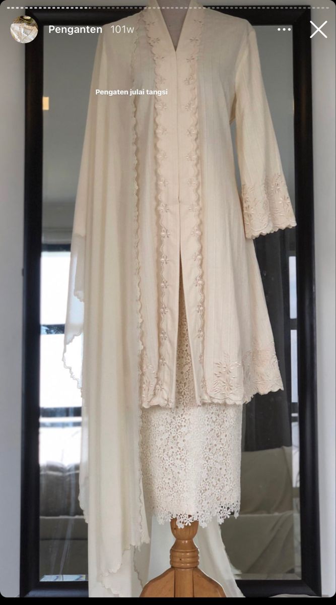 a white dress and jacket on display in front of a mirror