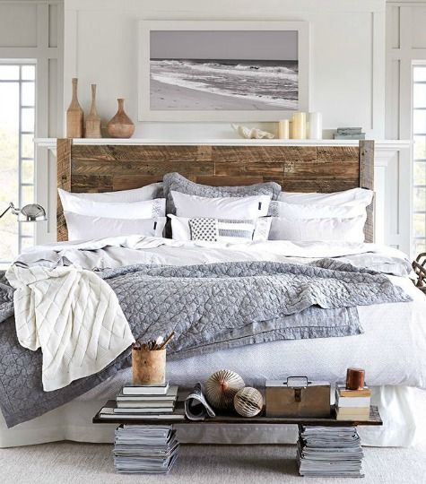 a bed with pillows and blankets on top of it next to a book shelf filled with books