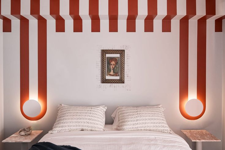 a bed with white and red striped walls in a bedroom