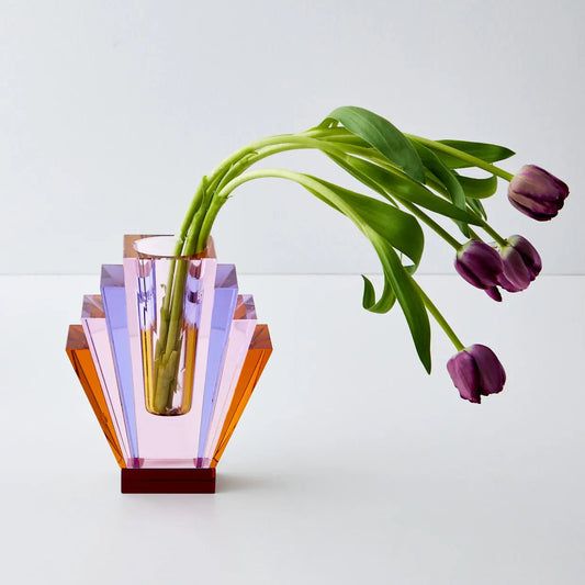 a glass vase with purple flowers in it