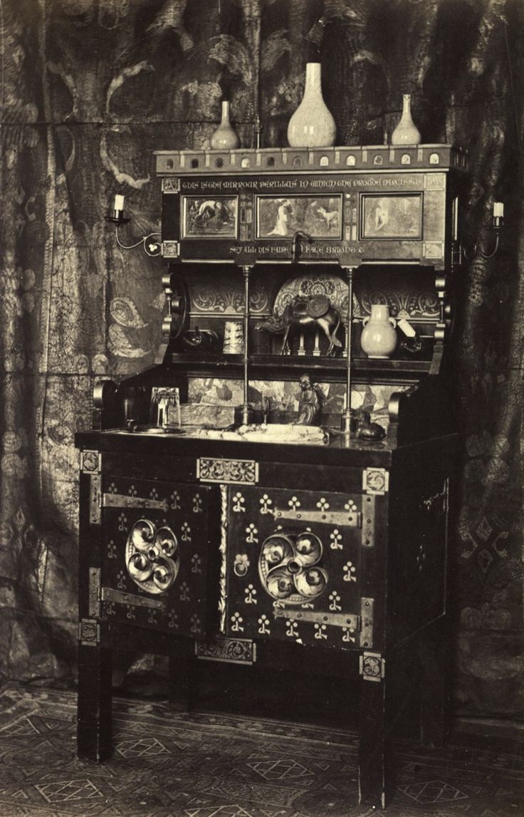 an old fashioned cabinet with vases and other items on it's top shelf