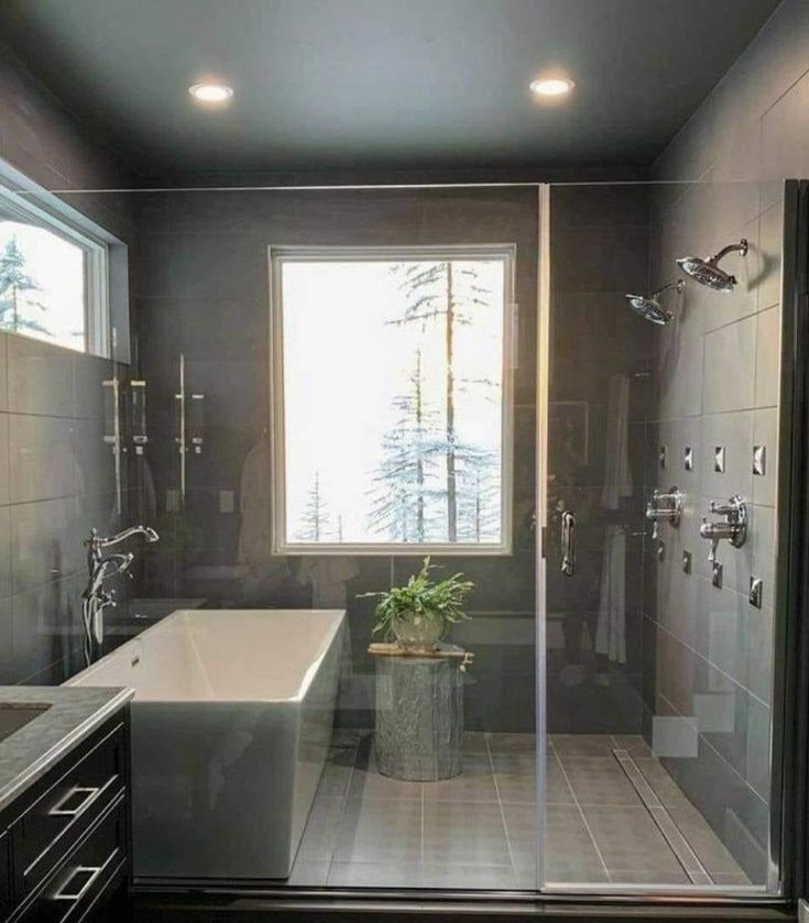 a bath room with a tub a sink and a window on the side of it