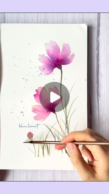 someone is painting flowers with watercolors on paper