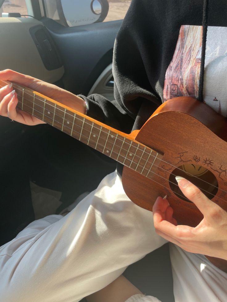 a person playing an ukulele in their car