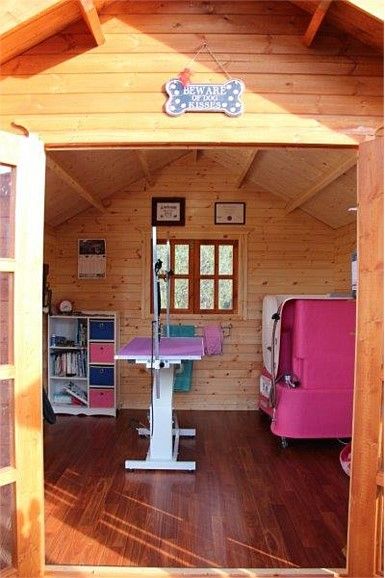 the inside of a small wooden house with wood floors and walls, including an open door