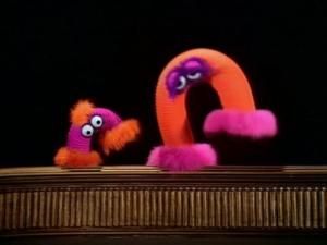 an orange and pink object sitting on top of a wooden table next to another item